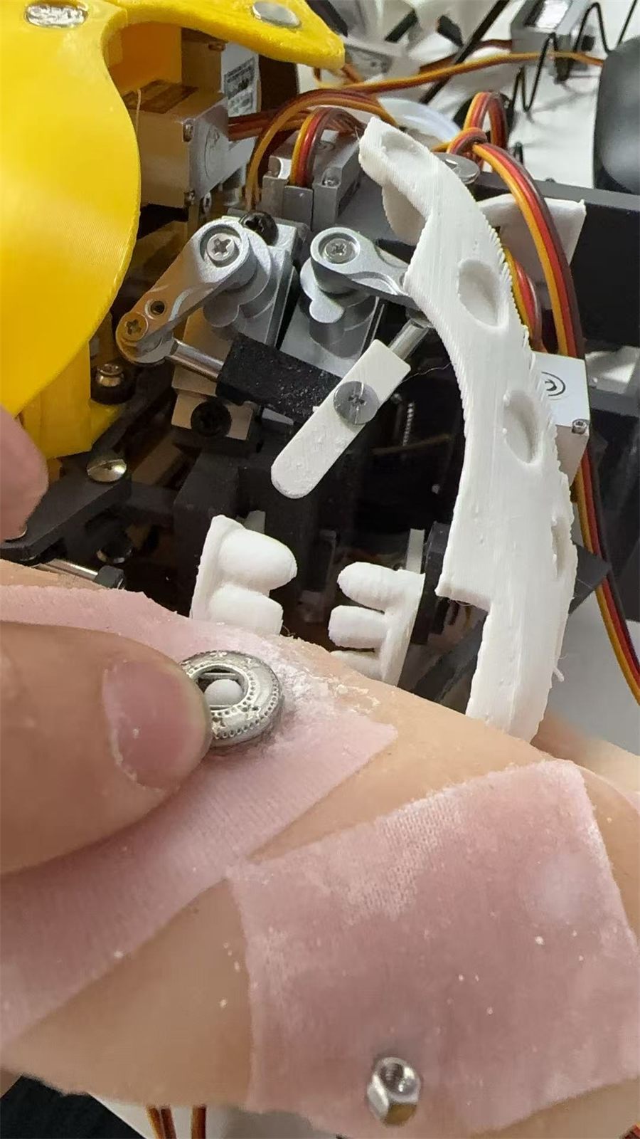 A snap fastener going through silicone skin onto the internal frame